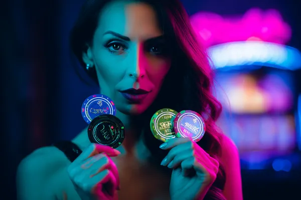 SAFI Slots — Thousands of thrilling machines await A woman smiling by bright slot machines showing lucky symbols, showcasing the exciting slot offerings at SAFI.